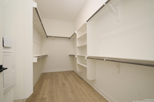 walk in closet with light hardwood / wood-style flooring