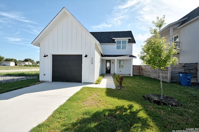 modern farmhouse featuring a garage and a front lawn