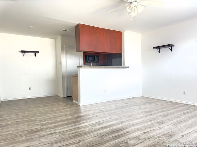 unfurnished living room featuring ceiling fan and light wood-type flooring