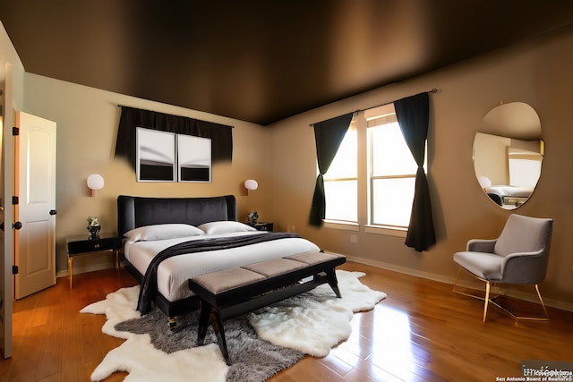bedroom featuring baseboards and wood finished floors