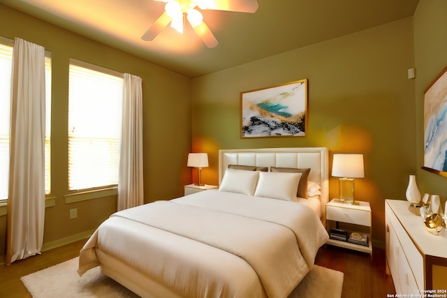 bedroom featuring a ceiling fan, baseboards, and dark wood finished floors