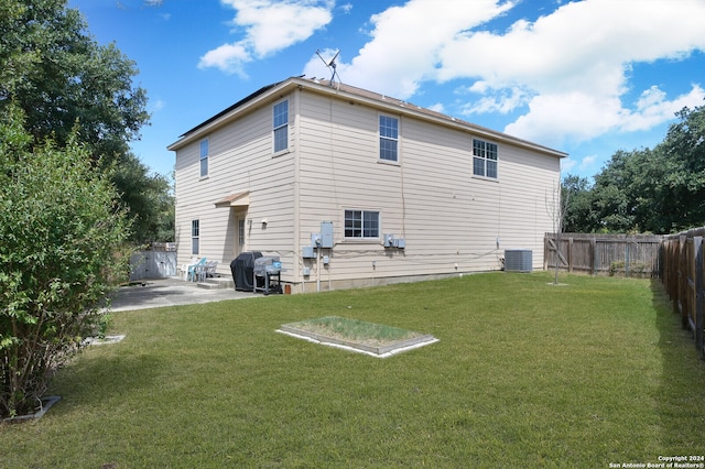 back of house featuring central air condition unit, a patio, and a lawn