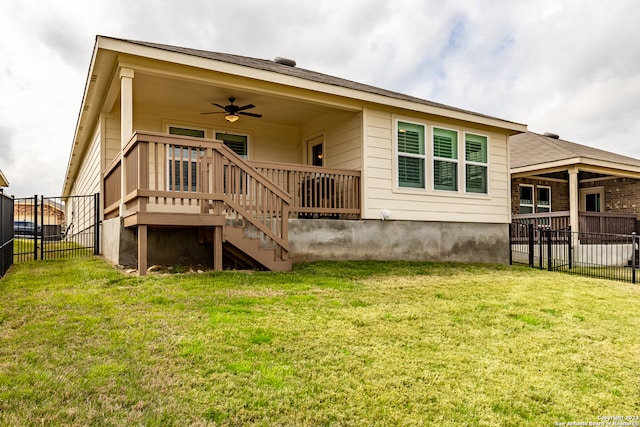 back of house featuring a lawn and ceiling fan