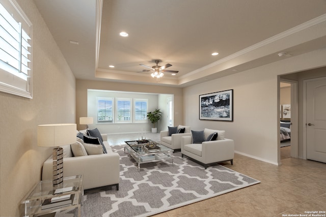 living room featuring ceiling fan, a raised ceiling, and tile patterned floors