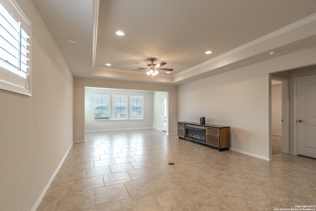 tiled living room with ceiling fan, a raised ceiling, and ornamental molding