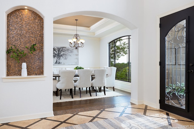 dining room with a wealth of natural light, crown molding, a notable chandelier, and wood-type flooring