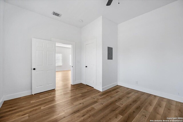 unfurnished bedroom with ceiling fan, hardwood / wood-style floors, and electric panel