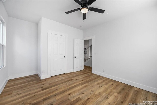 unfurnished bedroom featuring hardwood / wood-style floors and ceiling fan