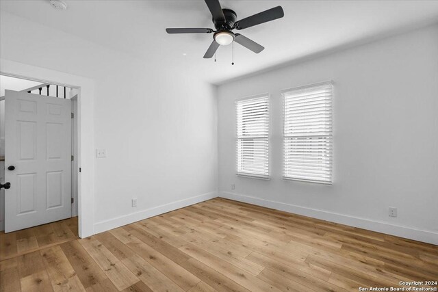 empty room with ceiling fan and light wood-type flooring