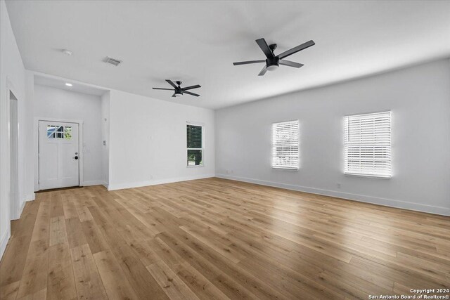 unfurnished living room featuring ceiling fan and light wood-type flooring