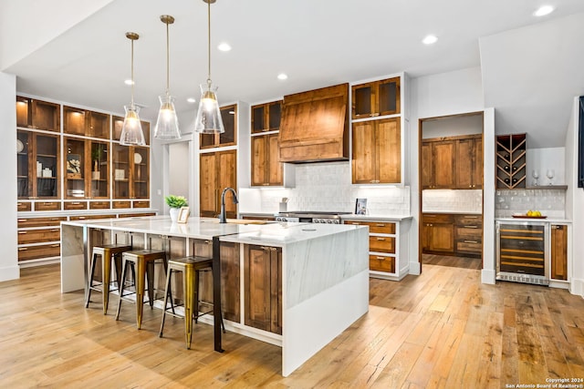 kitchen with custom exhaust hood, decorative backsplash, a large island, and beverage cooler