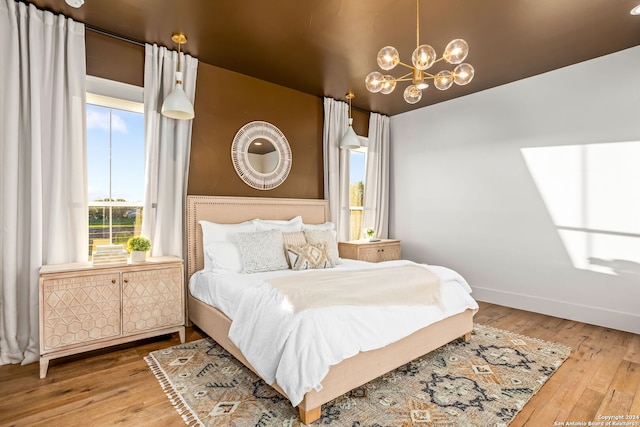 bedroom with hardwood / wood-style floors and a chandelier