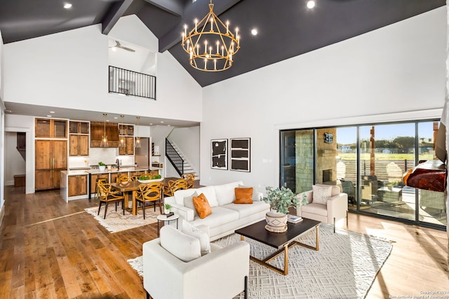 living room featuring hardwood / wood-style floors, beam ceiling, high vaulted ceiling, and a chandelier