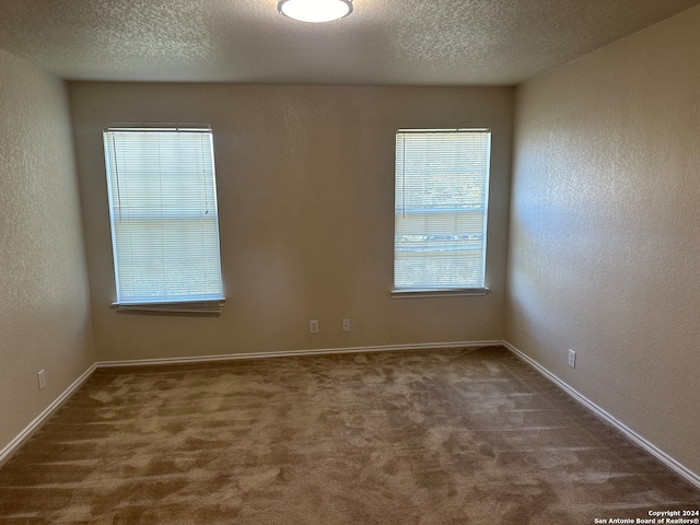 carpeted spare room featuring a textured ceiling