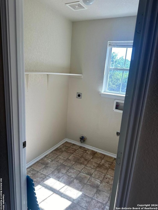 washroom with electric dryer hookup, light tile patterned flooring, and washer hookup