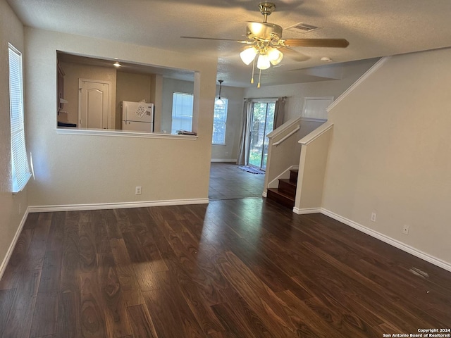 unfurnished living room featuring stairs, baseboards, and dark wood-type flooring