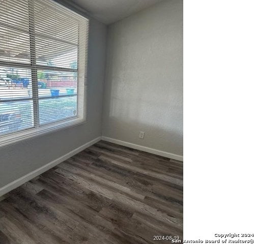 unfurnished room with dark wood-type flooring