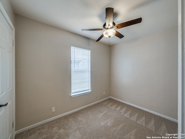 spare room with ceiling fan, plenty of natural light, and carpet