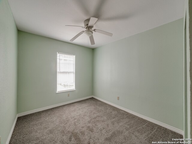 spare room with ceiling fan and carpet