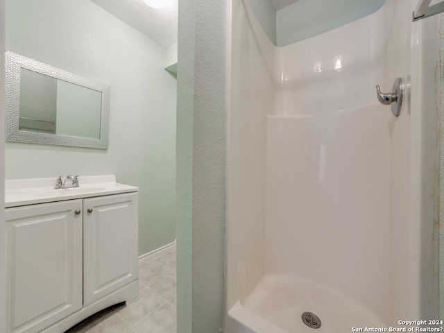 bathroom featuring vanity, walk in shower, and tile patterned floors