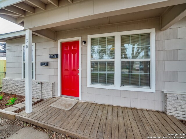 view of exterior entry with a deck