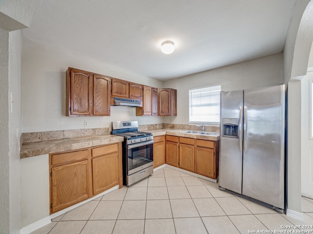 kitchen featuring light tile patterned flooring, sink, and stainless steel appliances