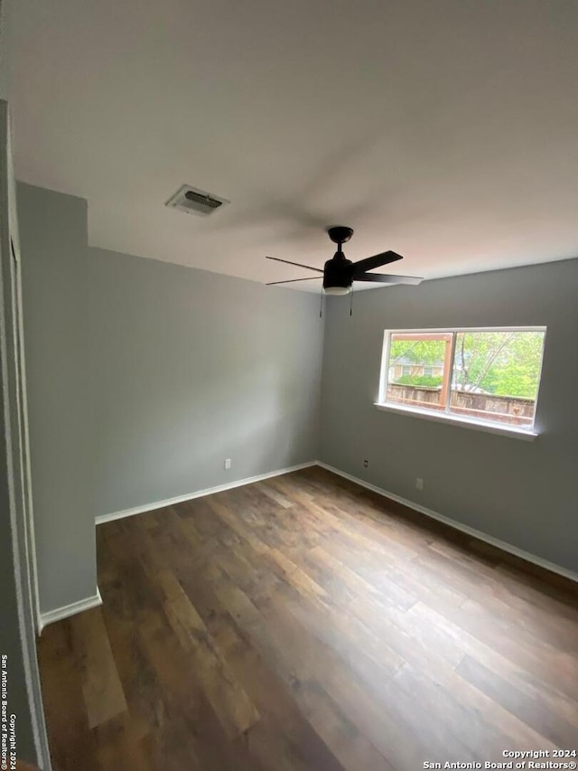 unfurnished room with ceiling fan and dark hardwood / wood-style floors