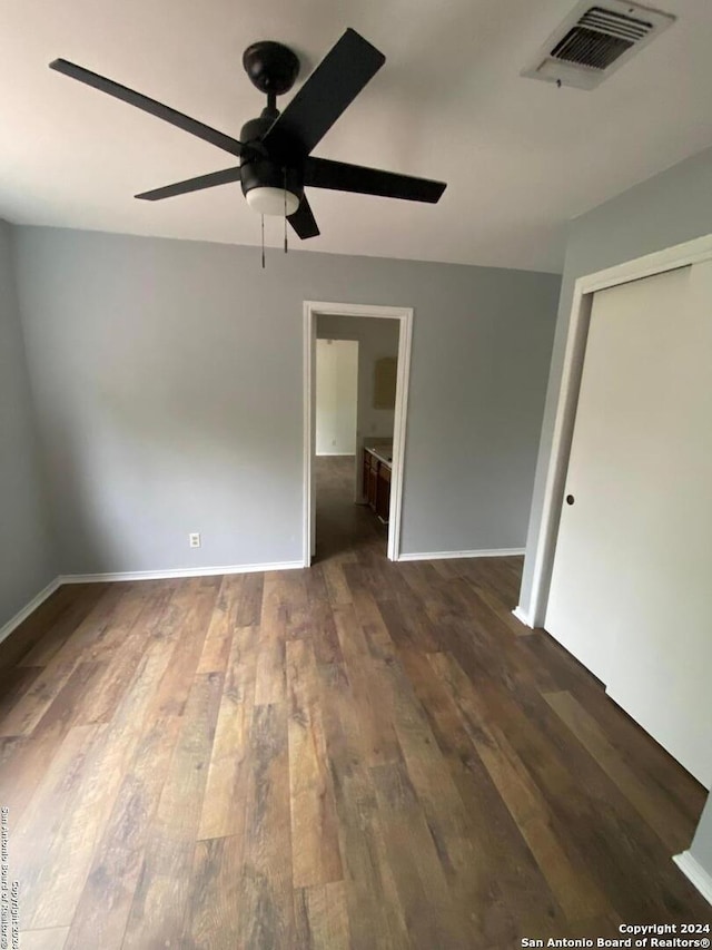 spare room with dark wood-type flooring and ceiling fan