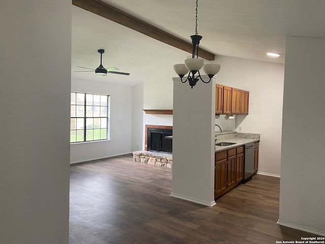 kitchen featuring dishwasher, dark wood-type flooring, ceiling fan with notable chandelier, vaulted ceiling with beams, and a stone fireplace