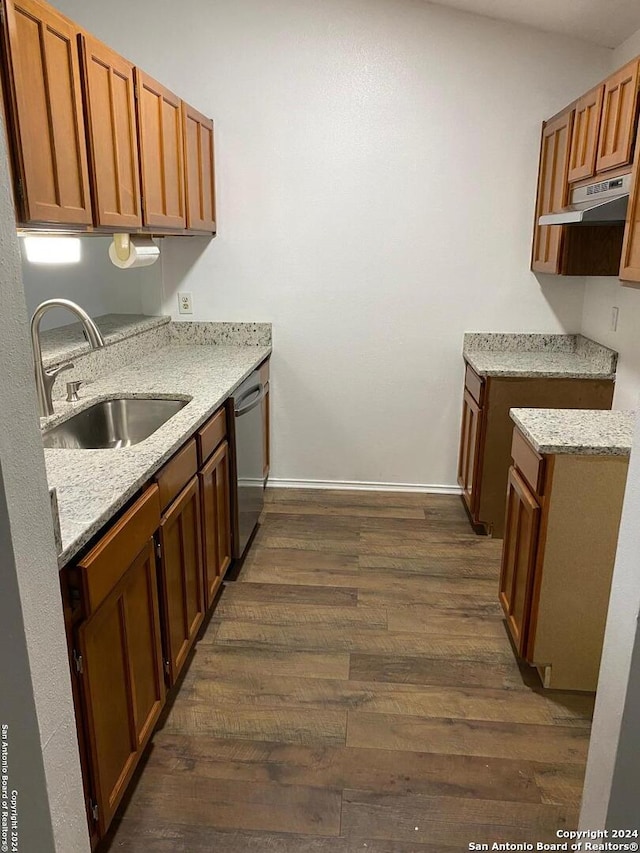 kitchen featuring dishwasher, light stone counters, dark wood-type flooring, and sink