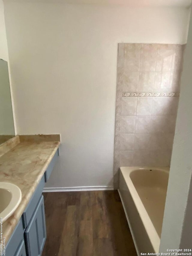 bathroom with vanity, a bathing tub, and hardwood / wood-style flooring