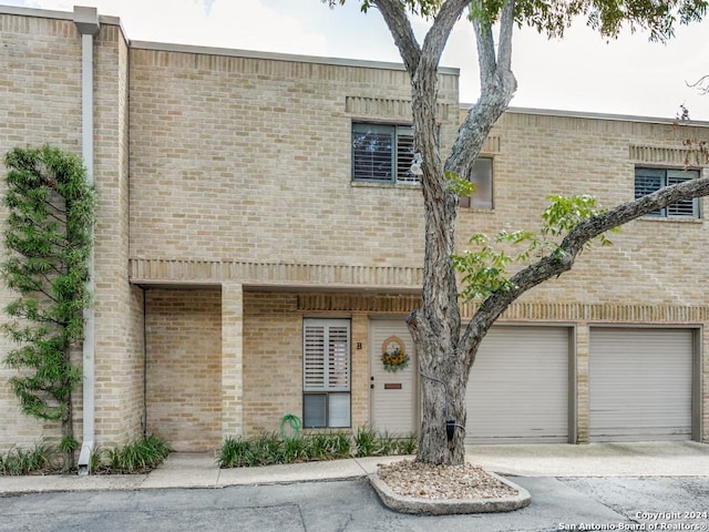 8123 N New Braunfels Ave Unit B, San Antonio, TX 78209 - view of property featuring a garage, concrete driveway, and brick siding