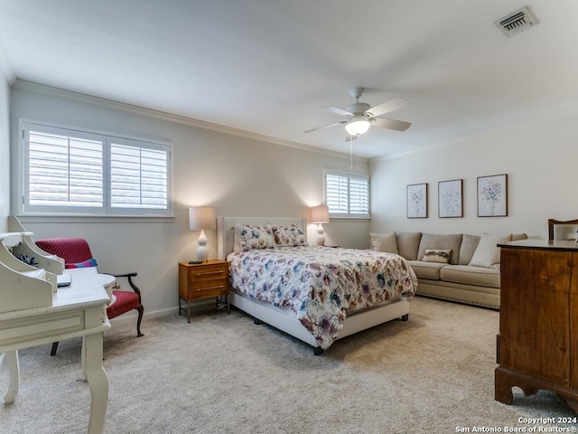 bedroom featuring light colored carpet, visible vents, ornamental molding, ceiling fan, and baseboards