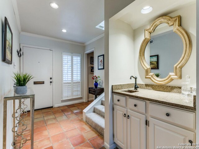 bathroom with tile patterned flooring, crown molding, and vanity