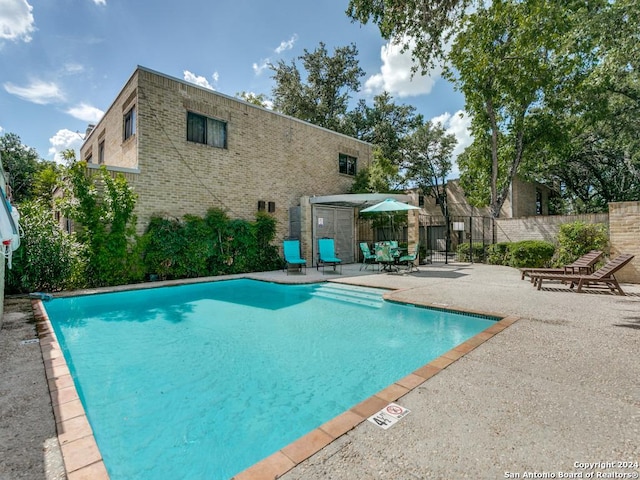 view of pool with a fenced in pool, a patio area, and fence