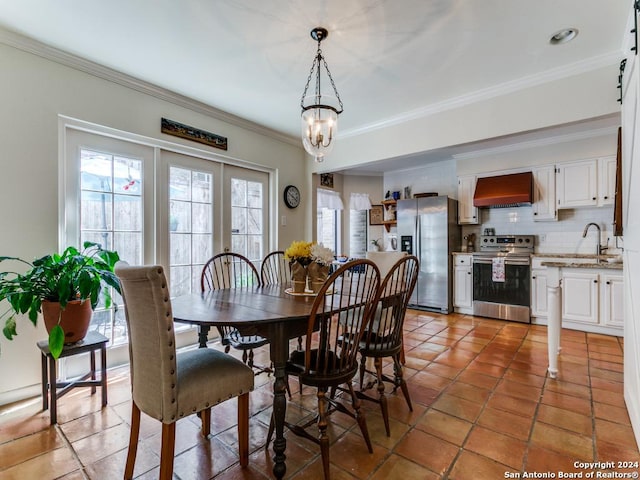 dining space with an inviting chandelier, ornamental molding, and dark tile patterned flooring