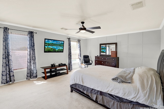 carpeted bedroom featuring ceiling fan and crown molding