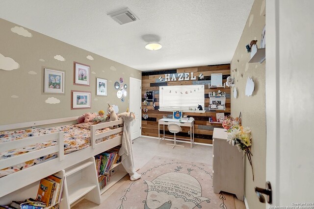 bedroom featuring a textured ceiling and wooden walls