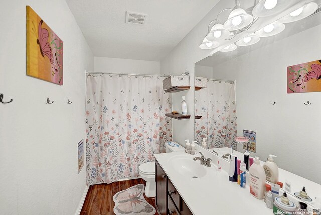 bathroom featuring hardwood / wood-style flooring, toilet, a textured ceiling, and vanity