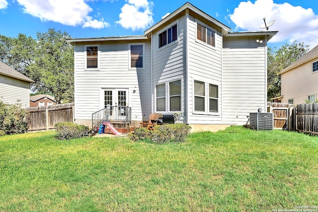 back of property with a lawn and central AC