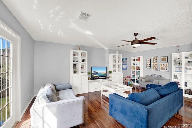 living room featuring ceiling fan, a textured ceiling, hardwood / wood-style floors, and a wealth of natural light