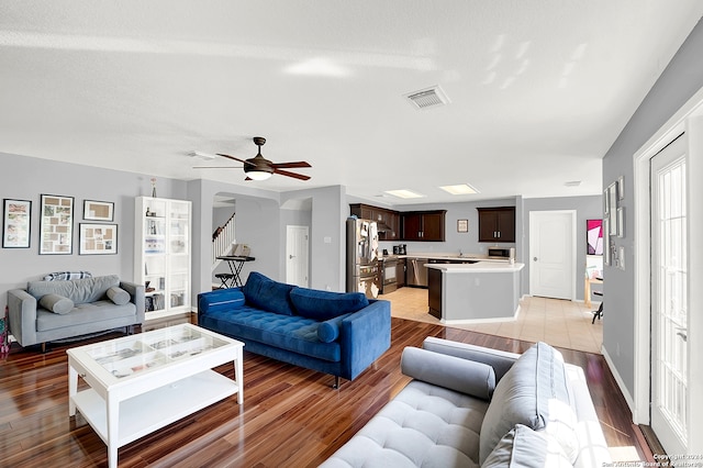 tiled living room featuring ceiling fan and sink