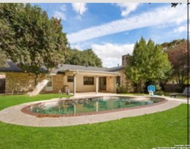 view of pool featuring a lawn