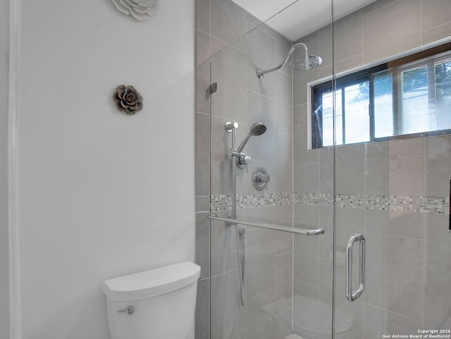 bathroom with toilet and an enclosed shower