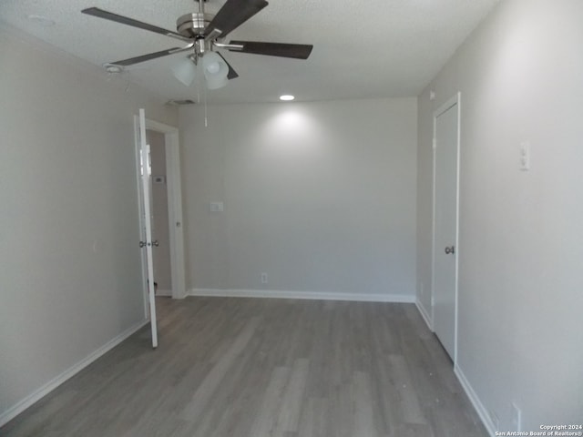 empty room featuring a textured ceiling, wood-type flooring, and ceiling fan