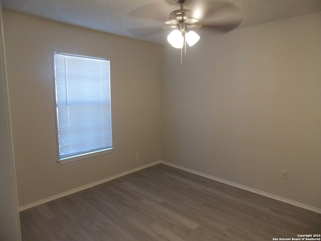 spare room featuring ceiling fan, dark hardwood / wood-style floors, and a textured ceiling