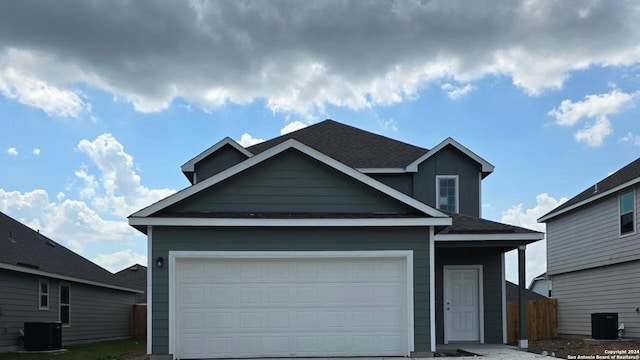 view of front of property with central AC unit and a garage