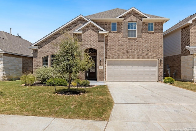 traditional home featuring an attached garage, concrete driveway, brick siding, and a front yard