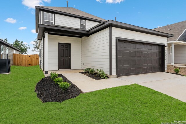 view of front facade with central AC unit, a garage, and a front yard