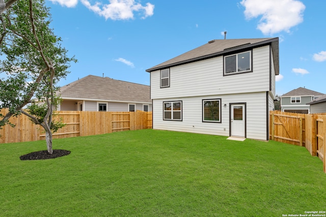 rear view of property with a lawn